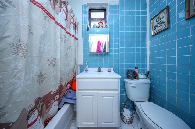 full bathroom featuring shower / bath combo with shower curtain, tile walls, vanity, and tile patterned flooring