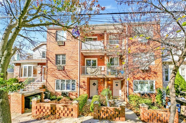 multi unit property with brick siding and a balcony