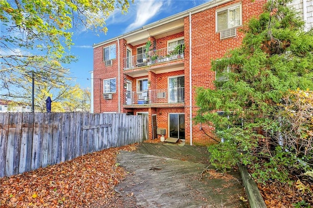 back of property with a balcony and cooling unit