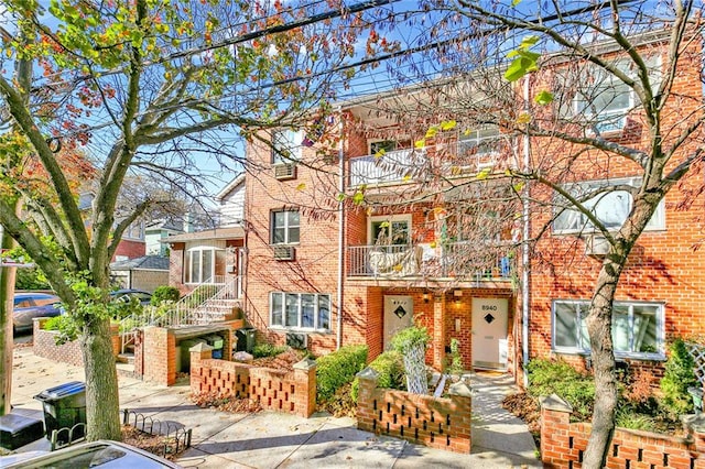view of front of property with brick siding and a balcony