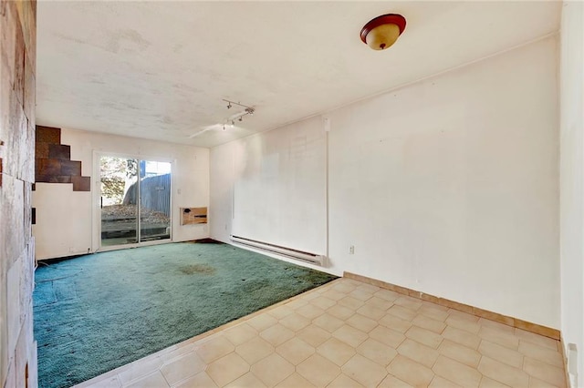 carpeted empty room with a baseboard radiator and rail lighting