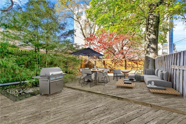 wooden terrace with a fenced backyard, outdoor dining space, outdoor lounge area, and a grill