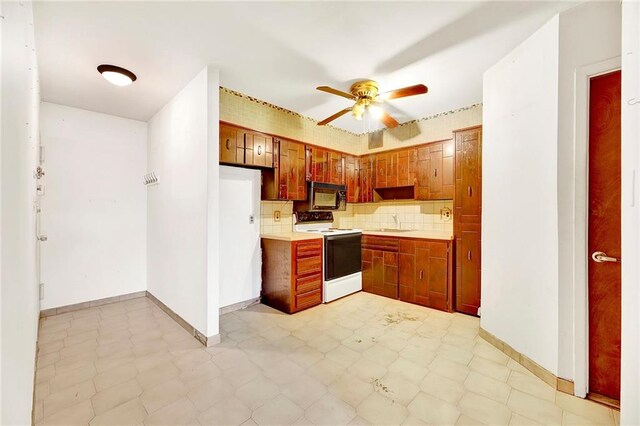 kitchen featuring tasteful backsplash, ceiling fan, sink, and white range with electric stovetop