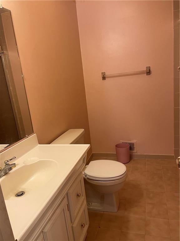 bathroom featuring tile patterned floors, vanity, walk in shower, and toilet