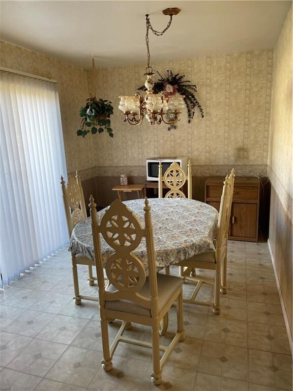 dining space featuring light tile patterned floors and an inviting chandelier