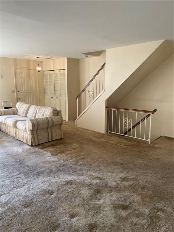 unfurnished living room featuring dark colored carpet