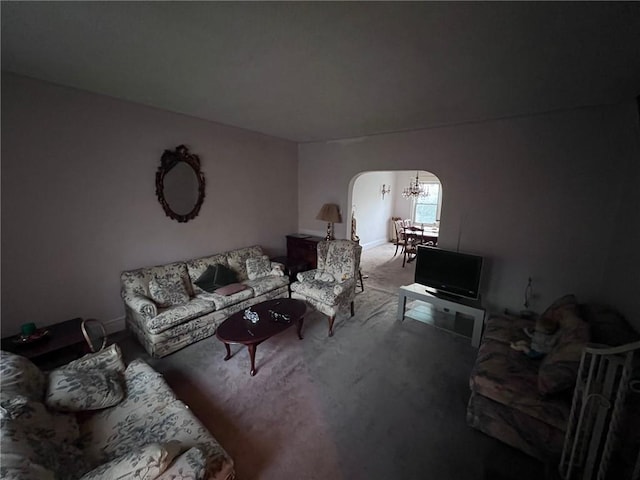 carpeted living room featuring arched walkways and a notable chandelier