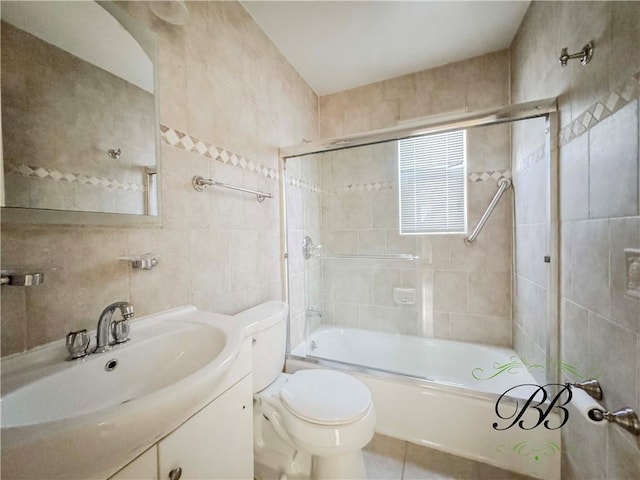 full bathroom with toilet, bath / shower combo with glass door, tile patterned flooring, tile walls, and vanity