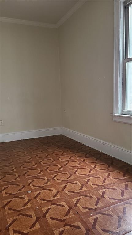 empty room with ornamental molding and parquet flooring