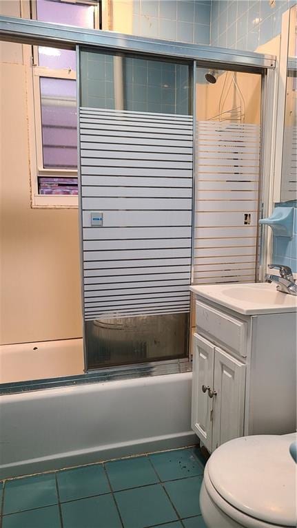 full bathroom featuring toilet, vanity, tile patterned floors, and enclosed tub / shower combo