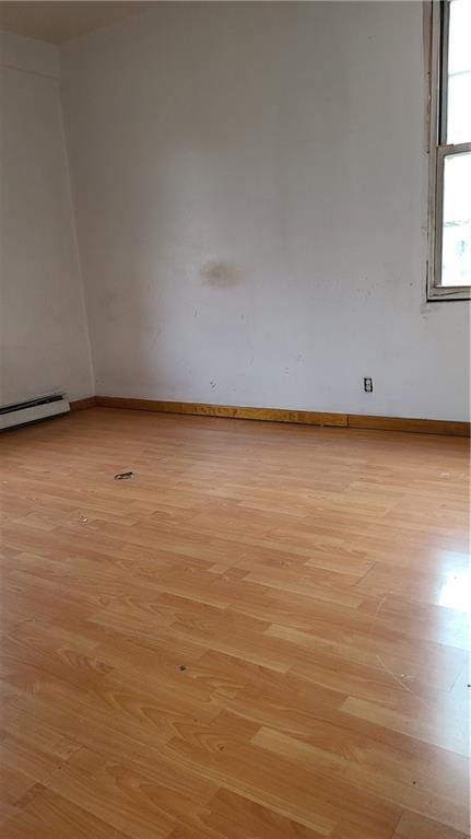 spare room with light hardwood / wood-style flooring and a baseboard heating unit