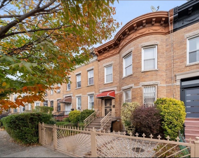 view of front of property with a fenced front yard and brick siding