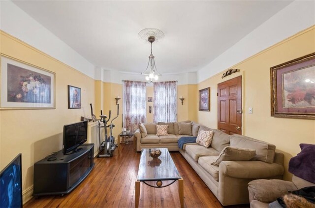 living room with dark hardwood / wood-style flooring and a notable chandelier