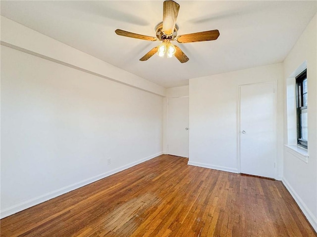 unfurnished bedroom with a ceiling fan, baseboards, and wood-type flooring