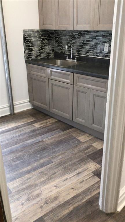 kitchen featuring gray cabinets, decorative backsplash, dark hardwood / wood-style floors, and sink