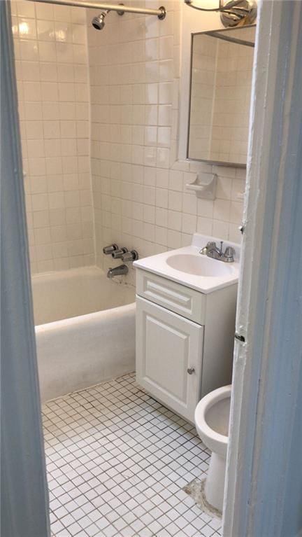 full bathroom with tile patterned flooring, toilet, vanity, tile walls, and tiled shower / bath