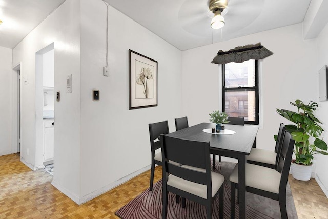 dining space featuring ceiling fan and light parquet flooring