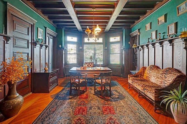 dining room featuring beamed ceiling, hardwood / wood-style floors, radiator heating unit, and a notable chandelier