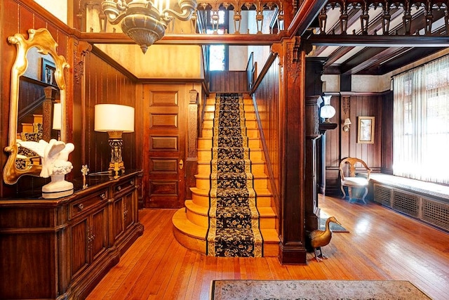 interior space featuring hardwood / wood-style floors, wooden walls, beamed ceiling, and a wealth of natural light