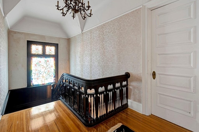 bedroom featuring a crib, wood-type flooring, and lofted ceiling