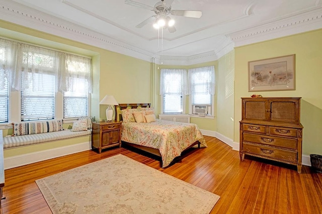 bedroom featuring wood-type flooring, ceiling fan, and crown molding