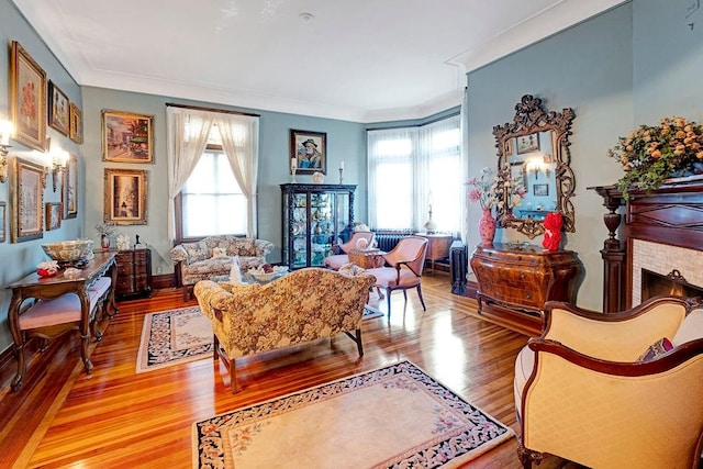 living area with plenty of natural light, wood-type flooring, and ornamental molding