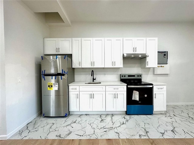 kitchen featuring electric range oven, freestanding refrigerator, marble finish floor, under cabinet range hood, and a sink