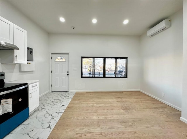 kitchen featuring a wall mounted air conditioner, electric range oven, white cabinetry, light countertops, and recessed lighting