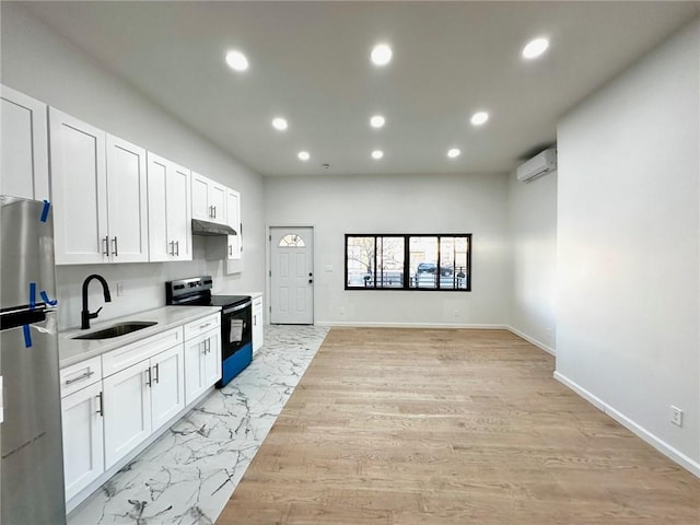 kitchen with electric stove, freestanding refrigerator, a sink, under cabinet range hood, and light countertops