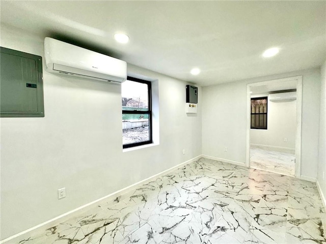 empty room with a wall unit AC, recessed lighting, baseboards, marble finish floor, and electric panel