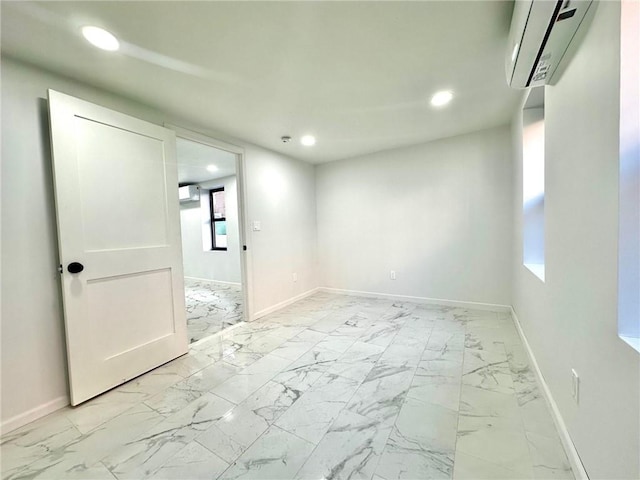 spare room featuring baseboards, a wall mounted air conditioner, marble finish floor, a wealth of natural light, and recessed lighting