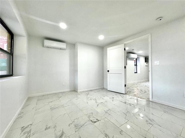 unfurnished room featuring an AC wall unit, baseboards, marble look tiles, and recessed lighting