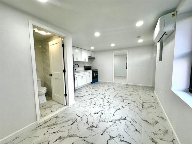 interior space featuring recessed lighting, baseboards, light marble finish floors, a sink, and an AC wall unit