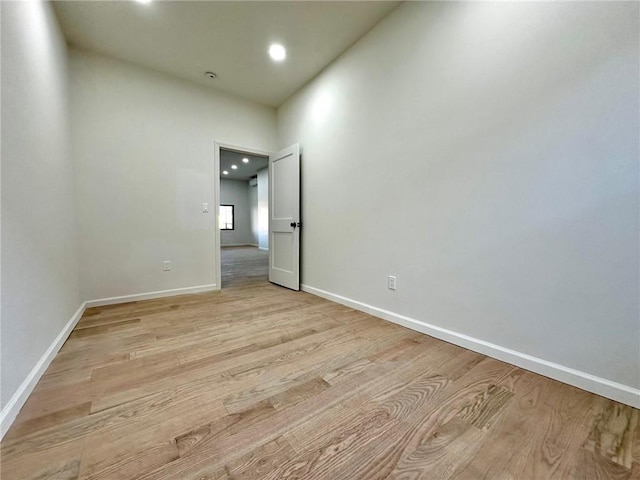 empty room with light wood-style floors, baseboards, and recessed lighting
