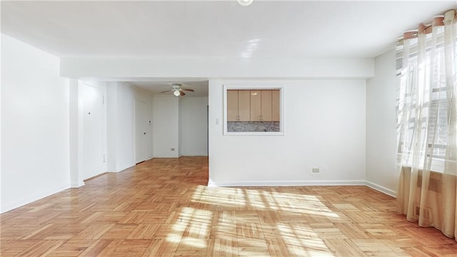 unfurnished room with ceiling fan and baseboards