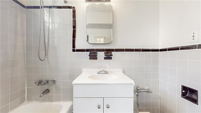 bathroom with tile walls, tub / shower combination, and vanity