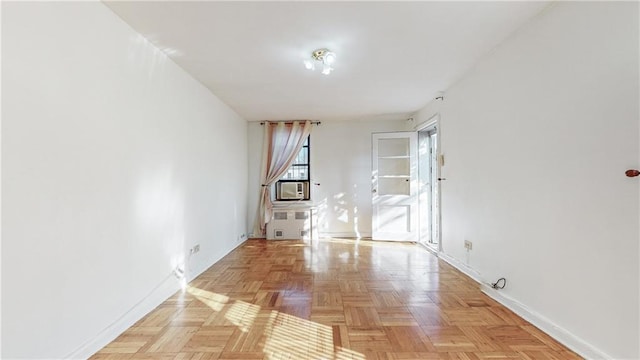 empty room featuring baseboards and cooling unit