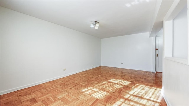 unfurnished room with baseboards