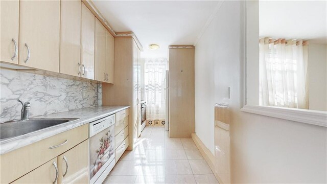 kitchen with light brown cabinetry, dishwasher, light countertops, a wealth of natural light, and a sink