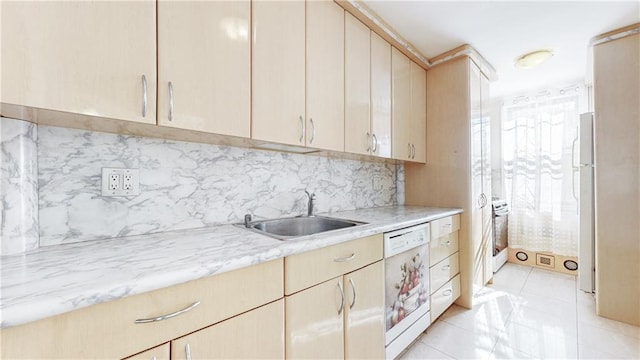 kitchen with light brown cabinets, light countertops, decorative backsplash, white appliances, and a sink