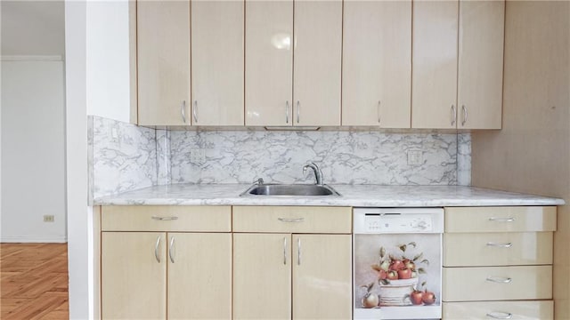 kitchen with a sink, light brown cabinets, backsplash, and white dishwasher