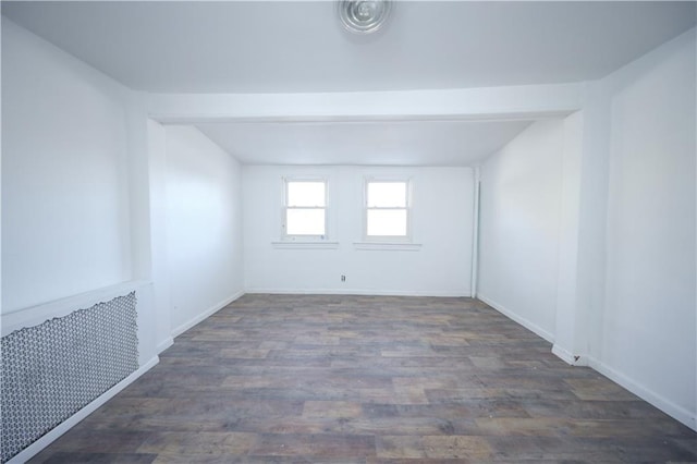 empty room featuring baseboards and wood finished floors