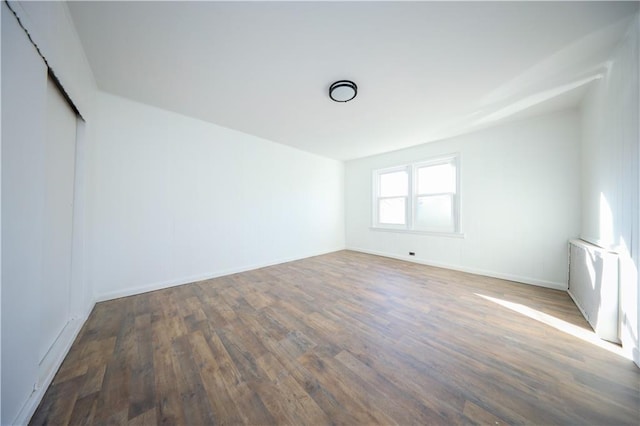 spare room with wood finished floors and baseboards