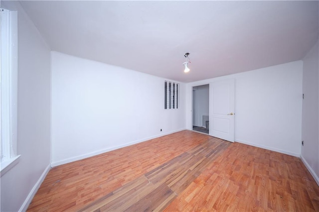 unfurnished bedroom featuring visible vents, light wood-style flooring, and baseboards