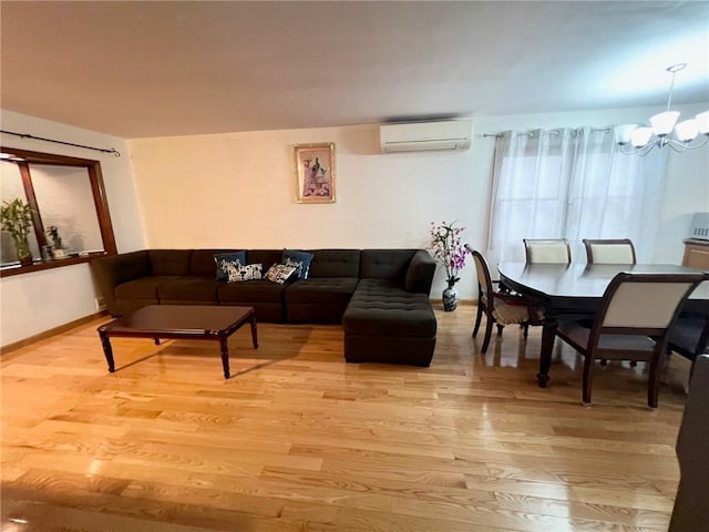 living room with light wood-type flooring, an inviting chandelier, and a wall mounted AC