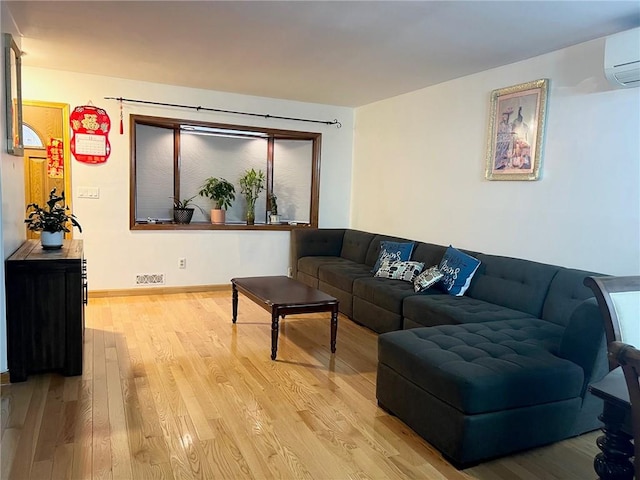 living room featuring light hardwood / wood-style flooring and a wall mounted AC