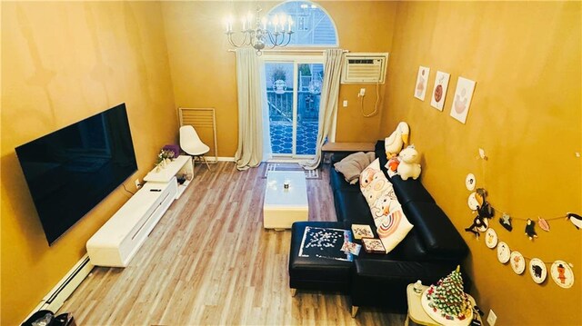 recreation room with hardwood / wood-style floors, a chandelier, a wall mounted air conditioner, and a baseboard radiator