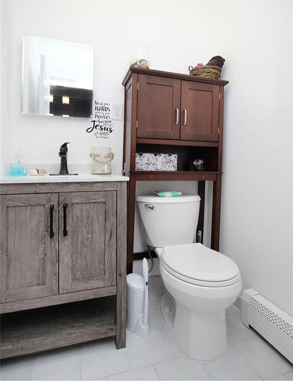 bathroom with vanity, toilet, and baseboard heating