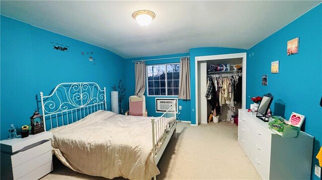 bedroom with a wall mounted AC, light carpet, a closet, and vaulted ceiling