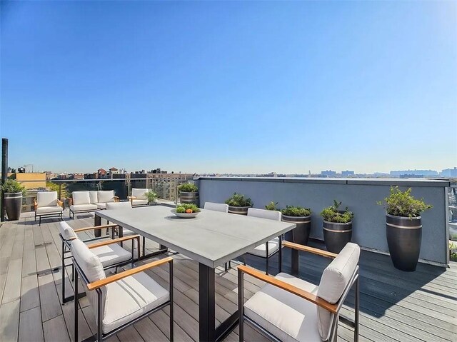 wooden deck featuring a water view and outdoor lounge area